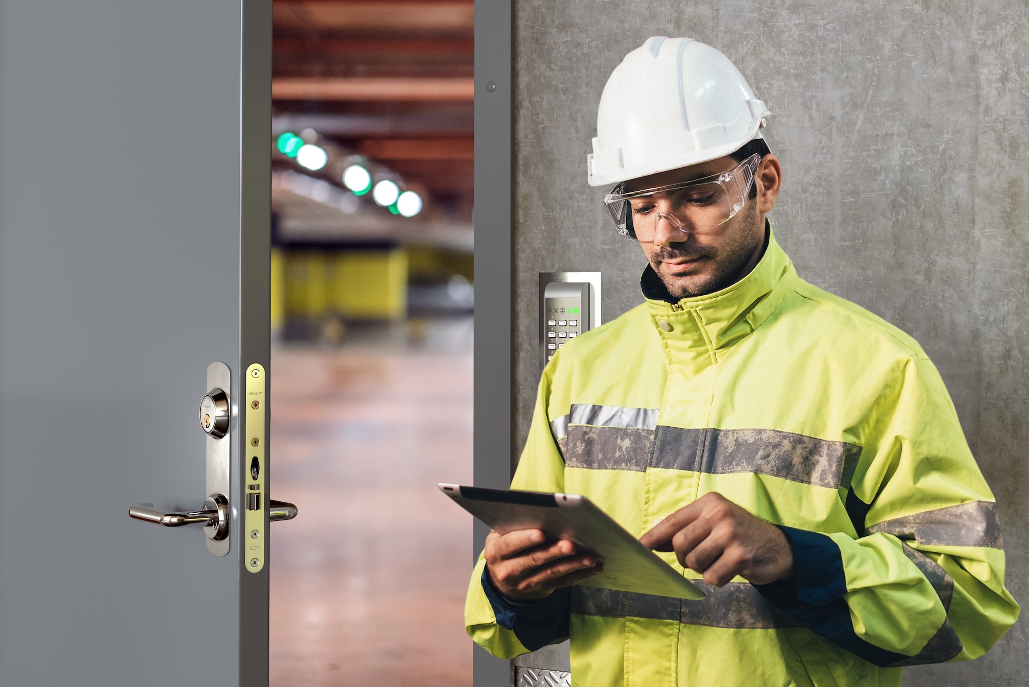 man med varseljacka och skyddshjälm står utanför dörr
